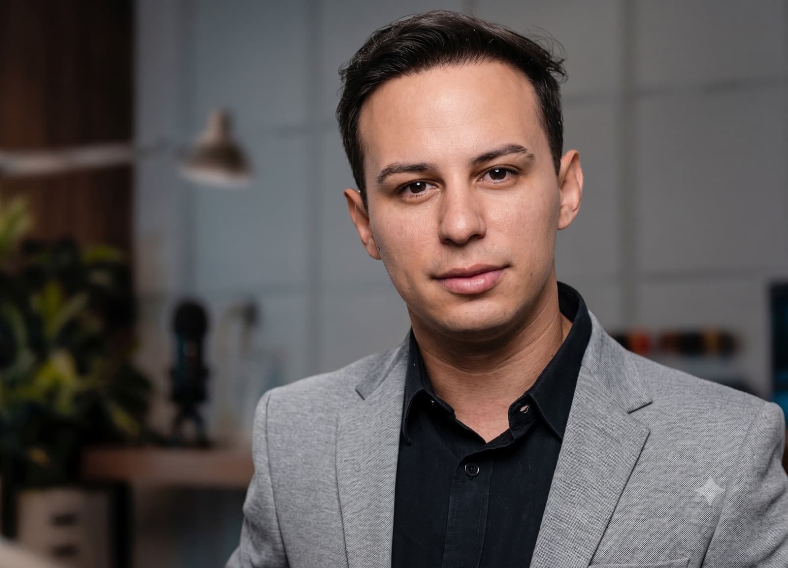 Dr. Lucas Moura em retrato editorial: blazer cinza, postura serena em preto e branco.